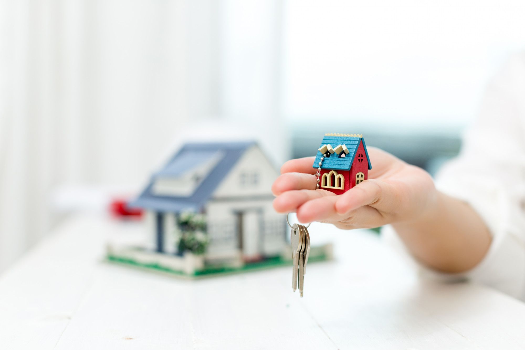 real-estate-agent-with-house-model-keys (1)